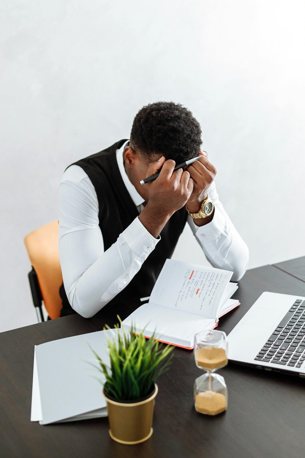 A stressed property professional with his head in his hands at a desk